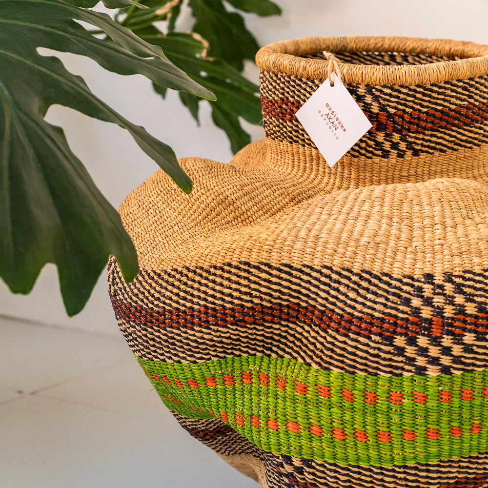 Decorative storage basket shaped like a garlic gourd with green and brown rings on the basket.  Designed by Akan Republic.