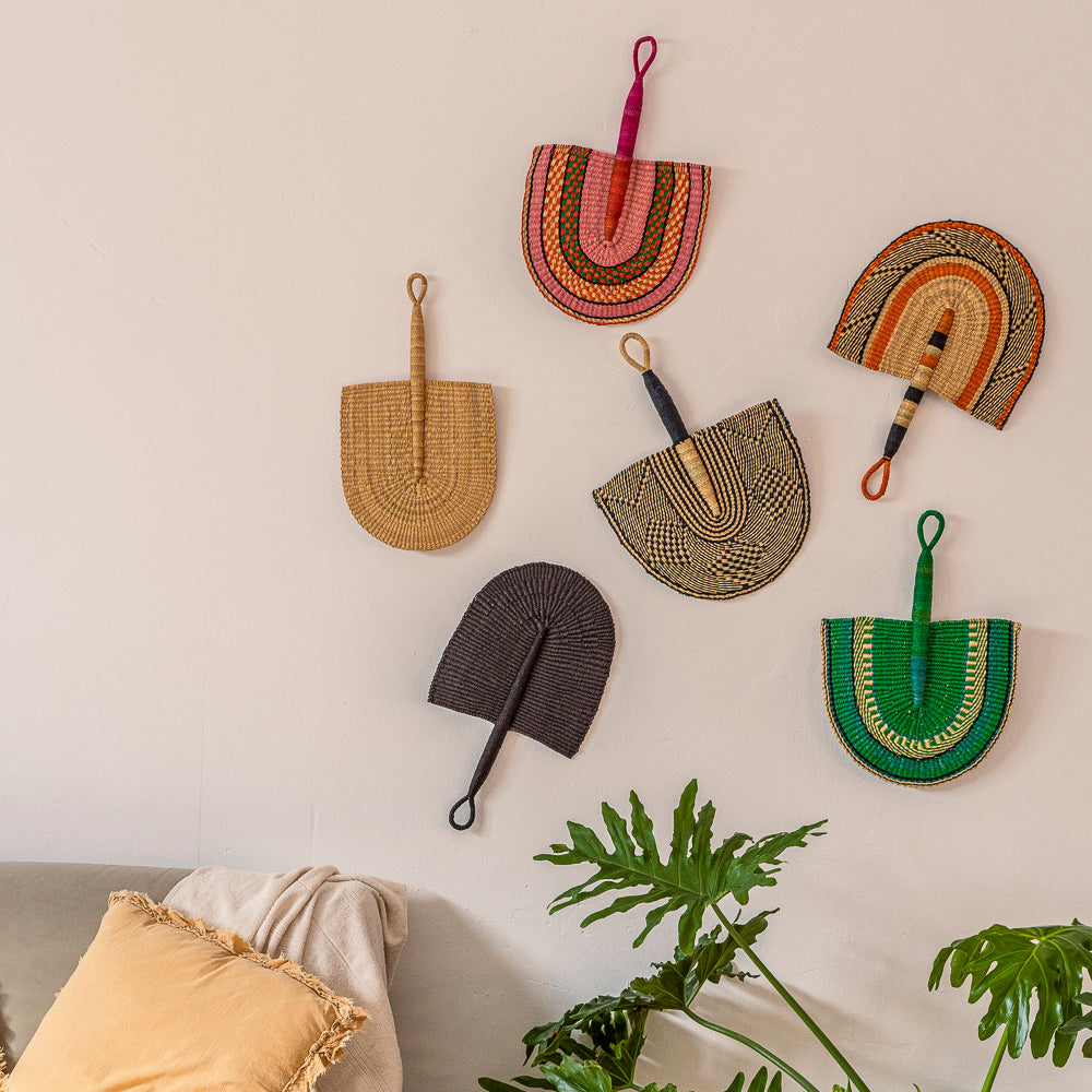 Wall decor of handheld fans in various colours and patterns.  Designed by Akan Republic. 