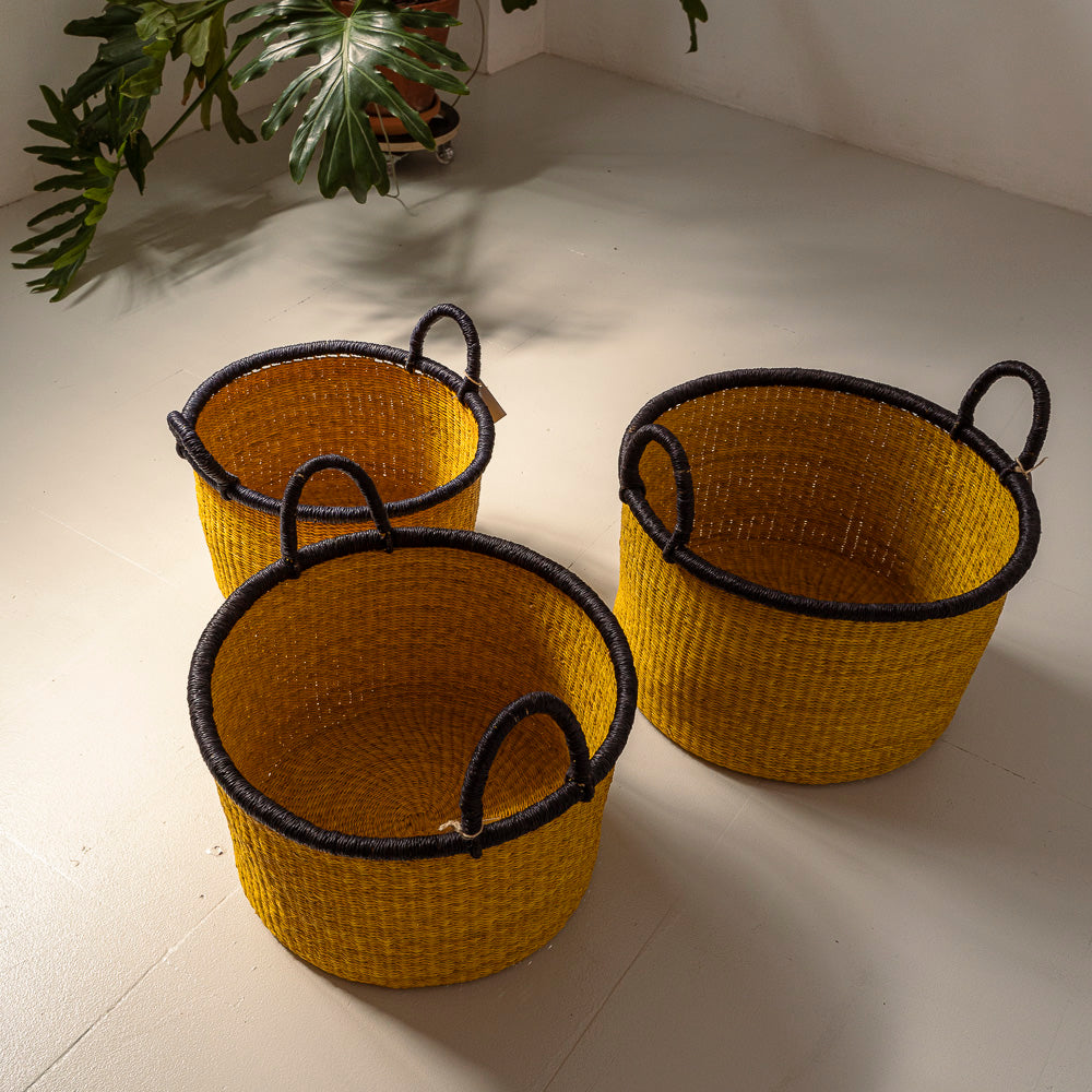 Storage baskets in 3 different sizes sitting on a studio floor. Designed by Akan Republic.